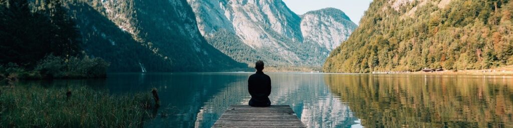 Incident manager looking at a mirror lake and mountains|Man at lake